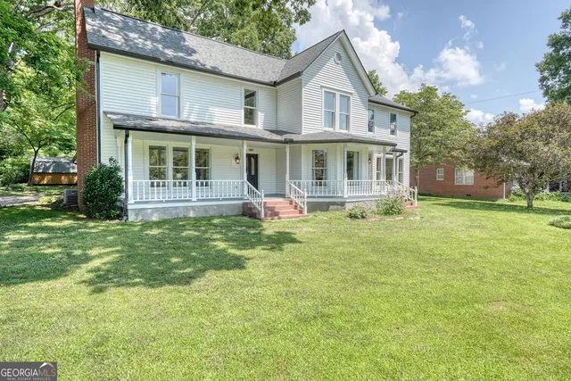 a front view of a house with a yard table and chairs