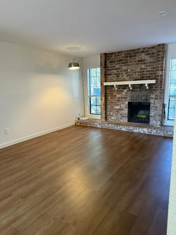 an empty room with wooden floor and fireplace