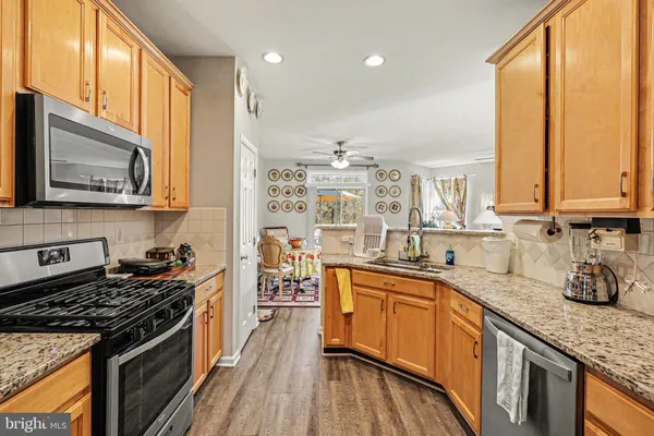 a kitchen with stainless steel appliances a sink a stove top oven a counter space and cabinets