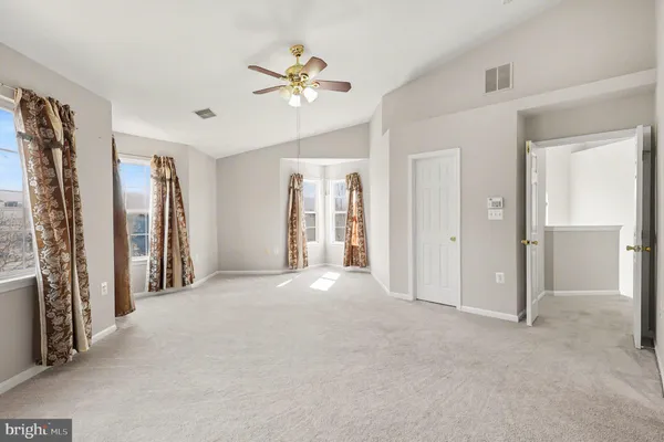 a view of an empty room with closet and a chandelier fan