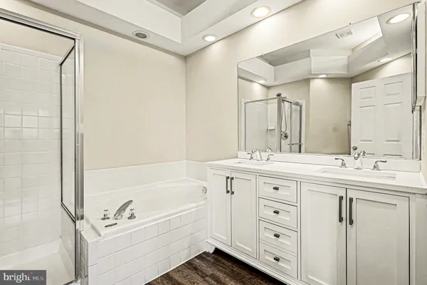 a bathroom with a tub a sink and mirror
