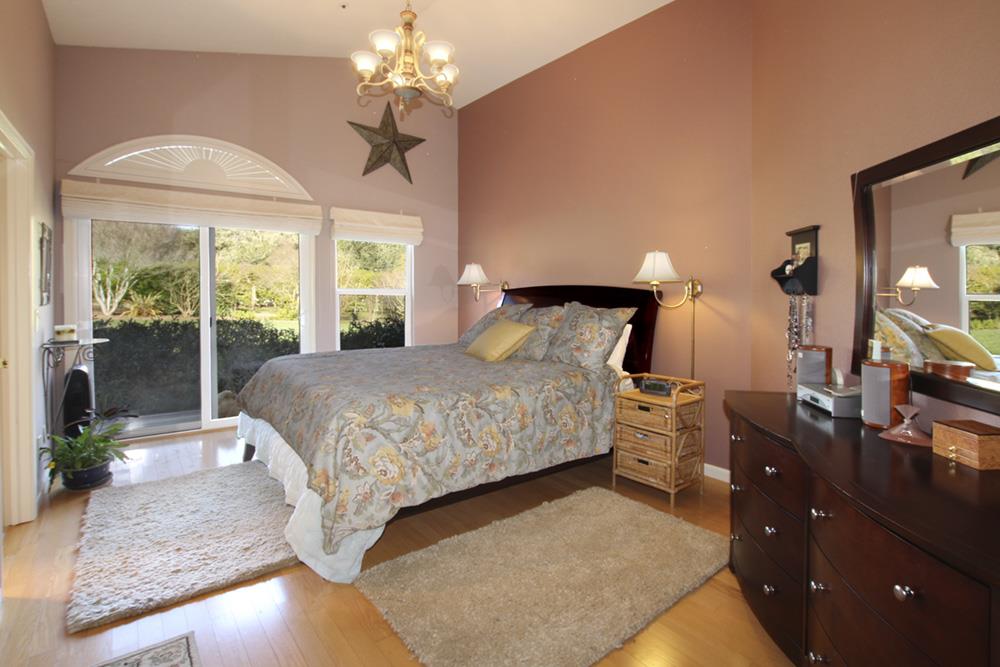 5 Nunes Road Watsonville, CA 95076 - Photo 15 of 41 a bedroom with a large bed and a chandelier
