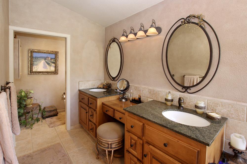 5 Nunes Road Watsonville, CA 95076 - Photo 19 of 41 a bathroom with a granite countertop toilet a sink and a mirror