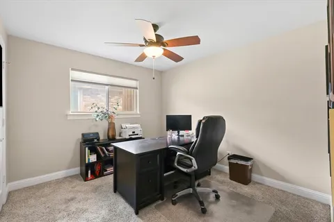 a view of a workspace with furniture and a window