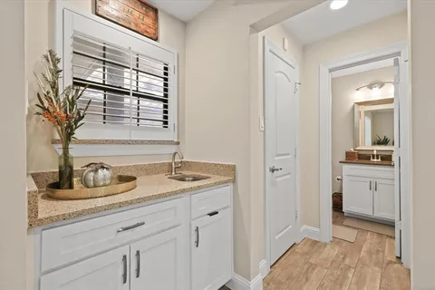 a en suite bathroom with a granite countertop sink and a mirror