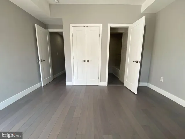 an empty room with wooden floor and closet