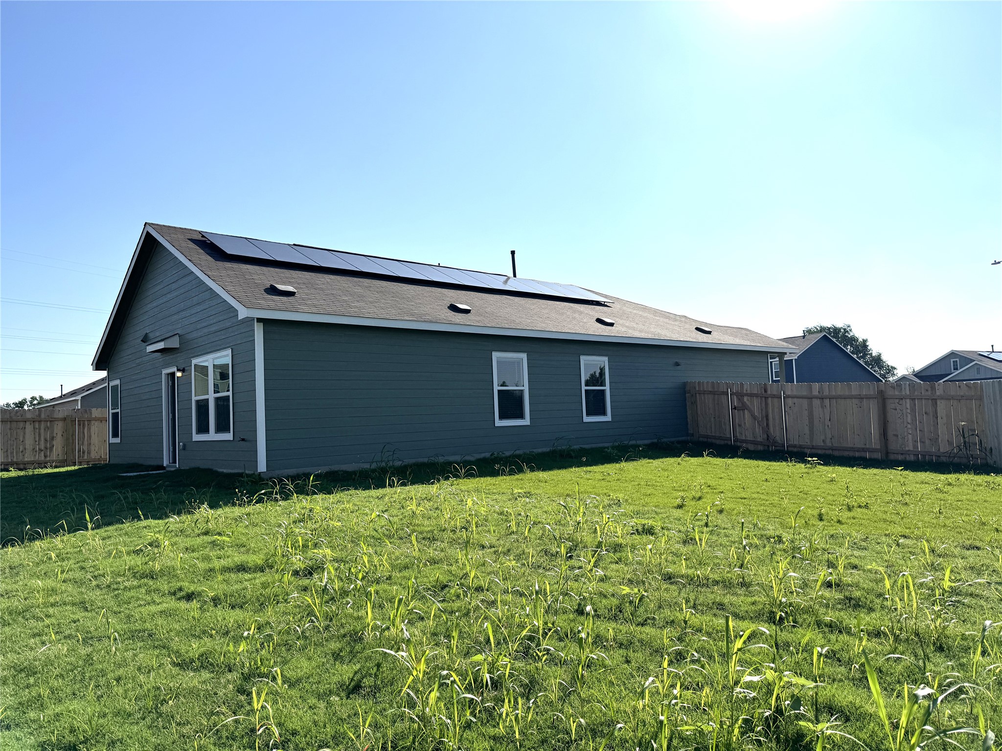 14408 Koti Way Pflugerville, TX 78660 - Photo 13 of 14 Rear view of property featuring a fenced backyard and roof mounted solar panels