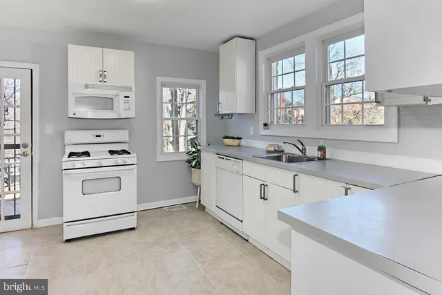 a kitchen with white cabinets and white appliances