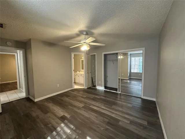 an empty room with wooden floor and bathroom