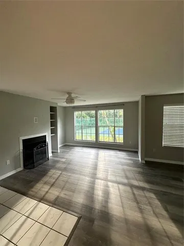 an empty room with fireplace and windows