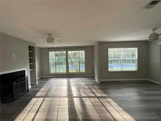 a view of an empty room with a fireplace and a window