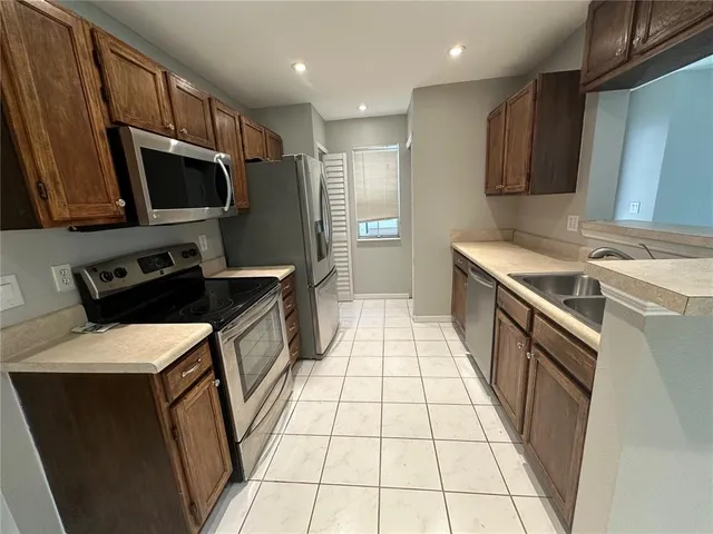 a kitchen with a sink a stove and a refrigerator