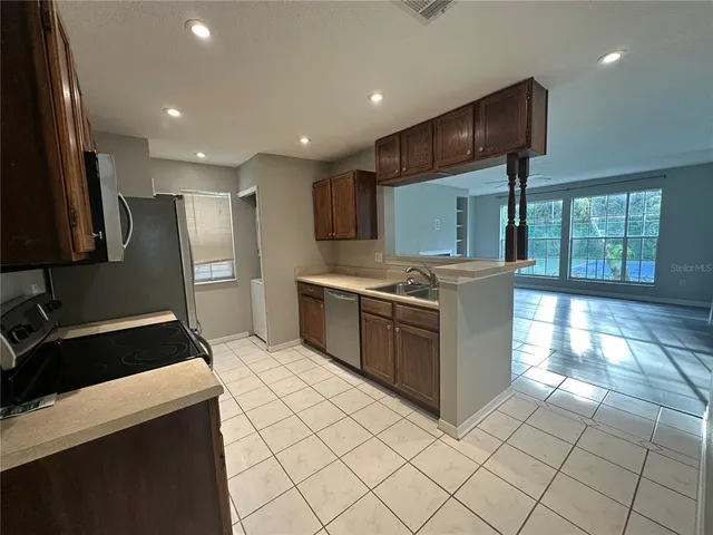 a kitchen with stainless steel appliances granite countertop a stove a sink and a refrigerator
