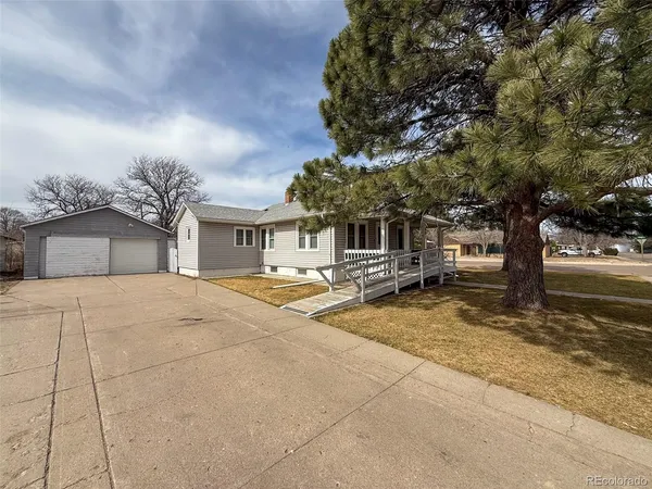 a view of a house with a yard garage and tree