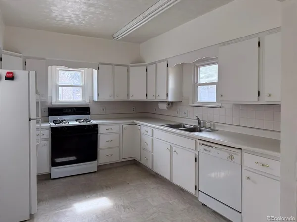 a kitchen with granite countertop white cabinets and black appliances