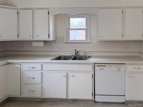 a kitchen with white cabinets and white appliances