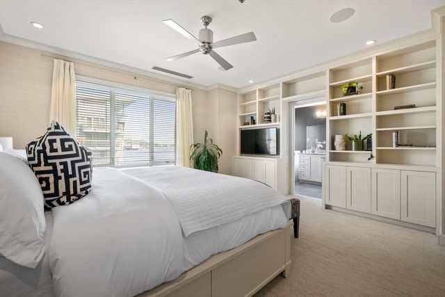 a bedroom with a bed next to a window and a chandelier