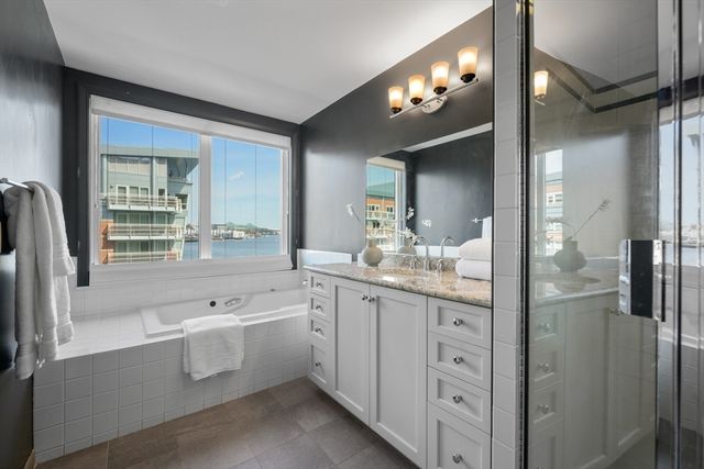 a bathroom with a granite countertop sink mirror and a bathtub