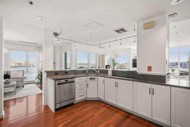 a large kitchen with cabinets and wooden floor