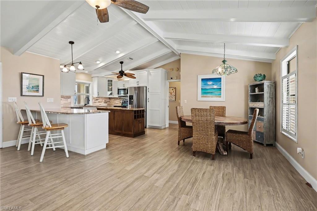 4838 Gary Road Bonita Springs, FL 34134 - Photo 12 of 29 a dining room with stainless steel appliances kitchen island granite countertop a table chairs and a refrigerator