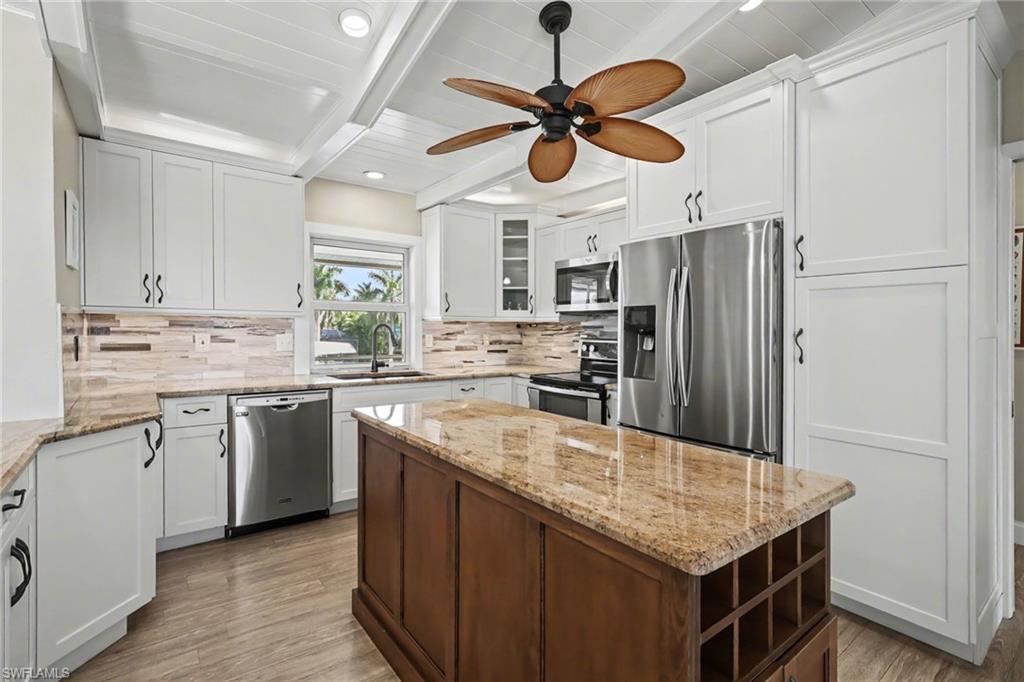 4838 Gary Road Bonita Springs, FL 34134 - Photo 5 of 29 a kitchen with stainless steel appliances granite countertop a sink a stove a refrigerator a washer dryer and white cabinets