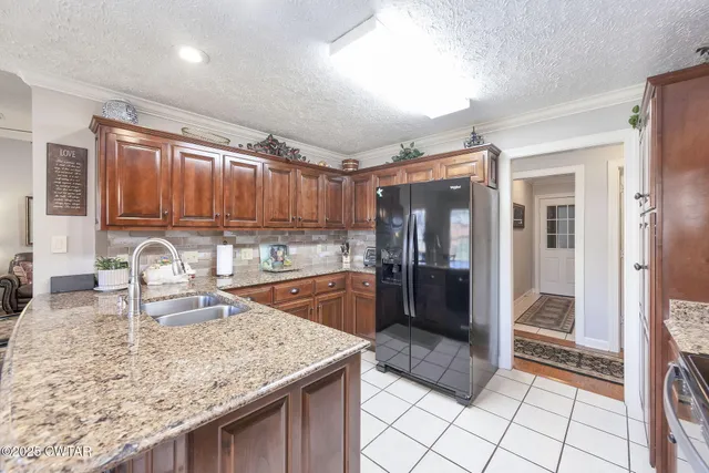 a kitchen with granite countertop a refrigerator and a sink