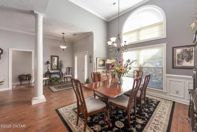 a view of a dining room with furniture wooden floor and a chandelier