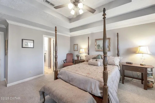 a bedroom with a bed a chandelier and a mirror