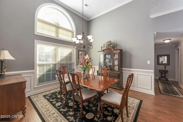 a view of a dining room with furniture a chandelier and wooden floor