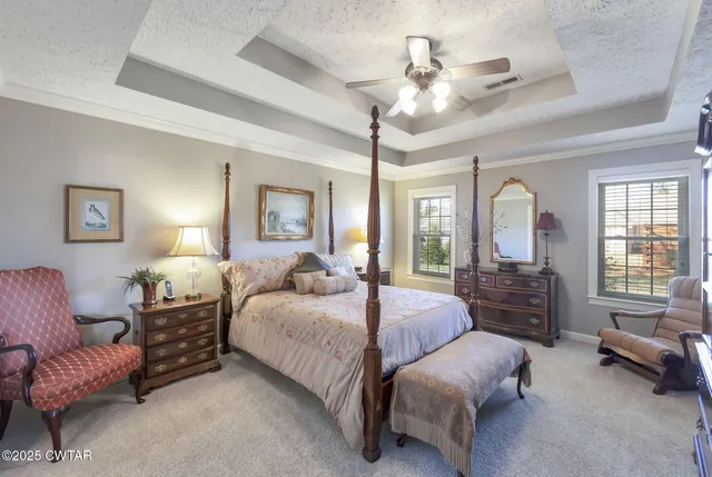 a spacious bedroom with a bed a couch and dresser