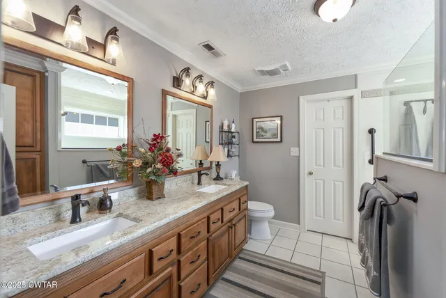 a bathroom with double vanity a mirror and a sink