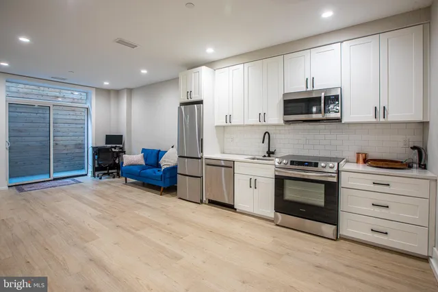 a kitchen with stainless steel appliances granite countertop a stove a sink and a refrigerator