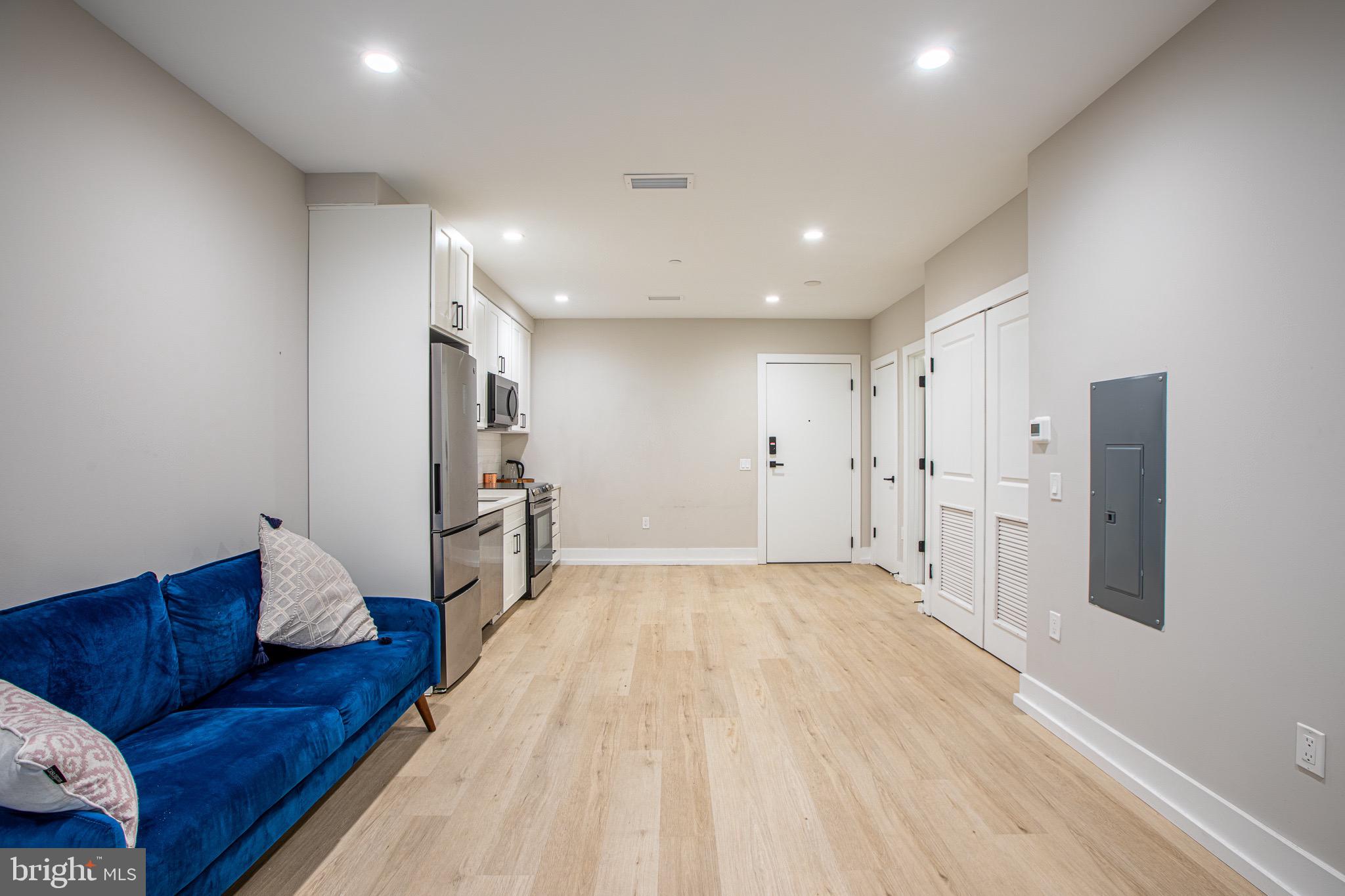 1016 17th Place Northeast, Unit 8 Washington, DC 20002 - Photo 16 of 21 a large room with a couch and a refrigerator