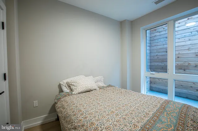 a bedroom with a bed and wooden floor