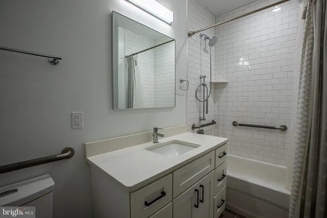 a bathroom with a sink toilet vanity and shower