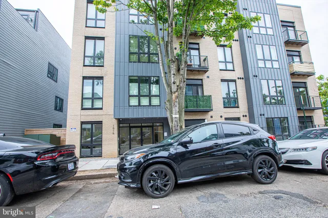 a front view of a residential apartment building with a parking space