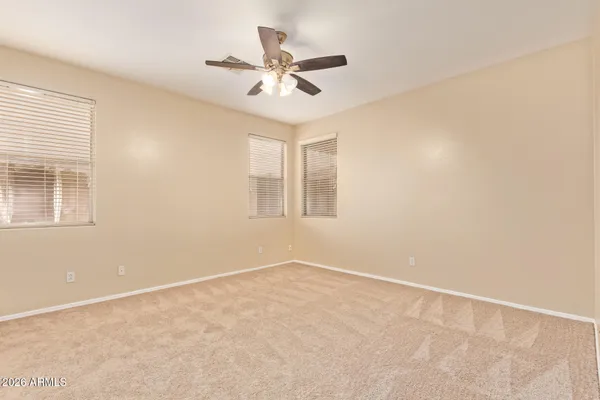 an empty room with a window and a ceiling fan