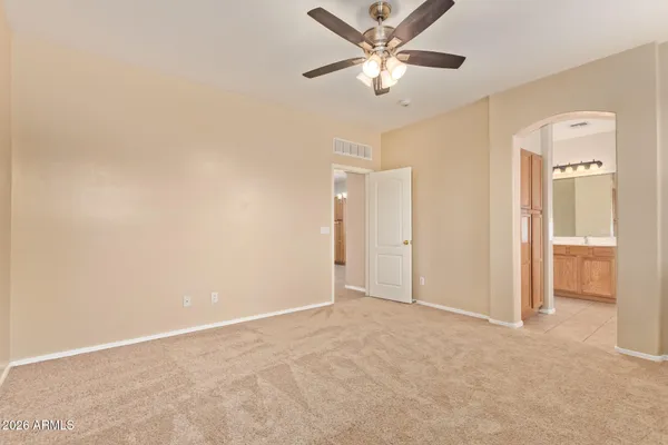 an empty room with closet and a ceiling fan