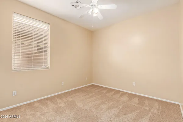 an empty room with a window and a ceiling fan