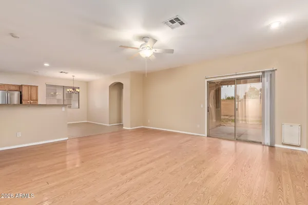 a view of an empty room with window and wooden floor