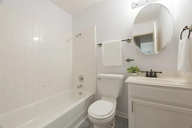 a bathroom with a sink toilet vanity tub and shower