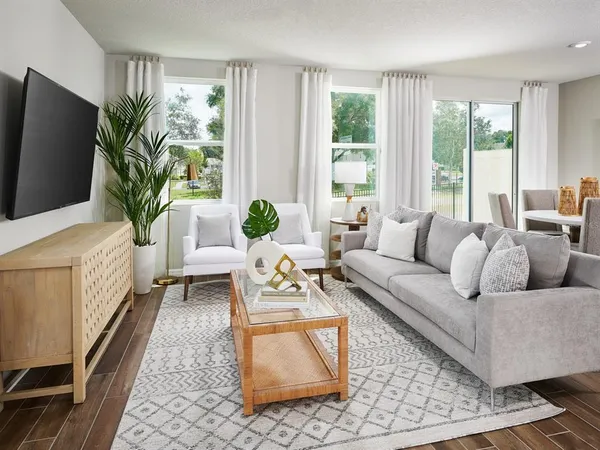 a living room with furniture a flat screen tv and a large window