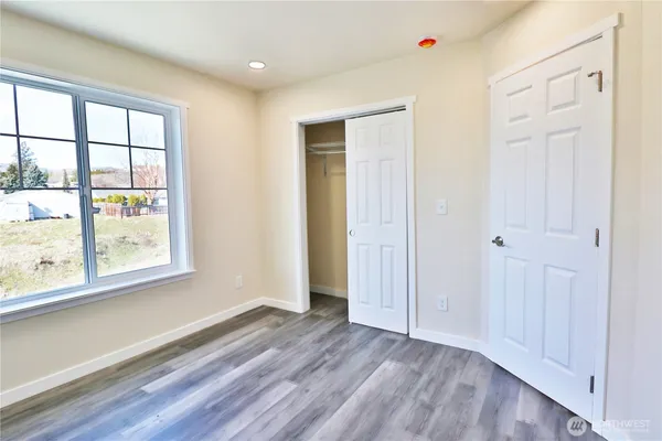 a view of empty room with wooden floor