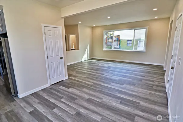 an empty room with wooden floor and a window
