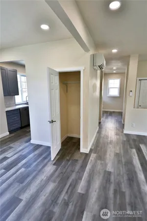 a view of a hallway with wooden floor and a bathroom