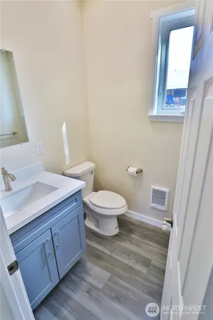 a bathroom with a toilet a sink and mirror