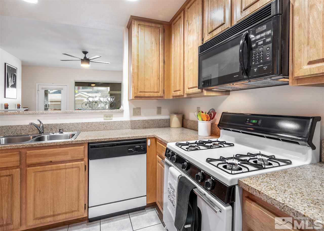 900 South, Unit 3413 Reno, NV 89521 - Photo 7 of 21 a kitchen with stainless steel appliances granite countertop a stove a sink dishwasher and a microwave