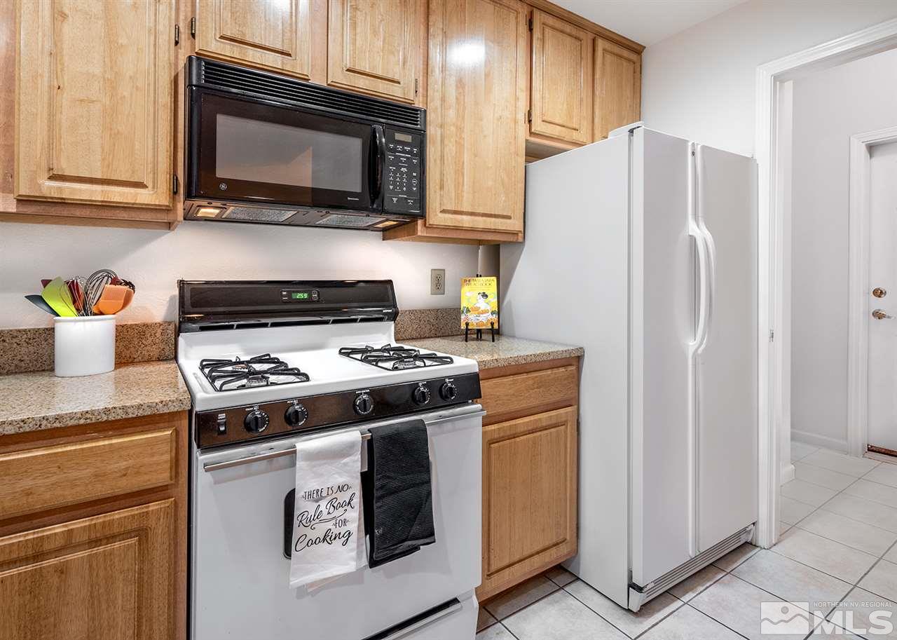900 South, Unit 3413 Reno, NV 89521 - Photo 8 of 21 a kitchen with stainless steel appliances a stove a microwave and cabinets