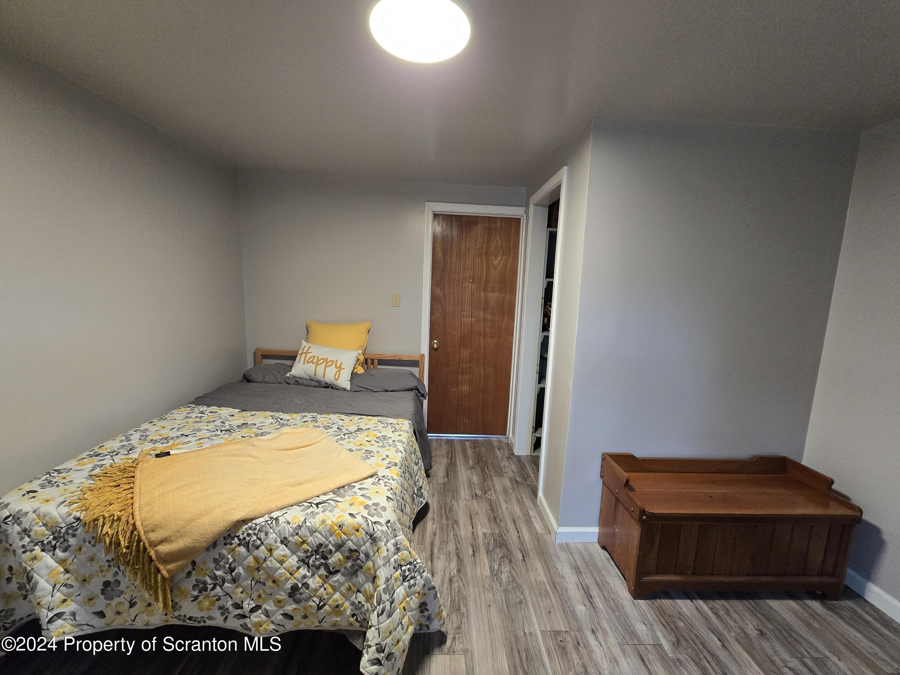 6736 Kingsley Road Kingsley, PA 18826 - Photo 13 of 42 a bedroom with a bed and wooden floor
