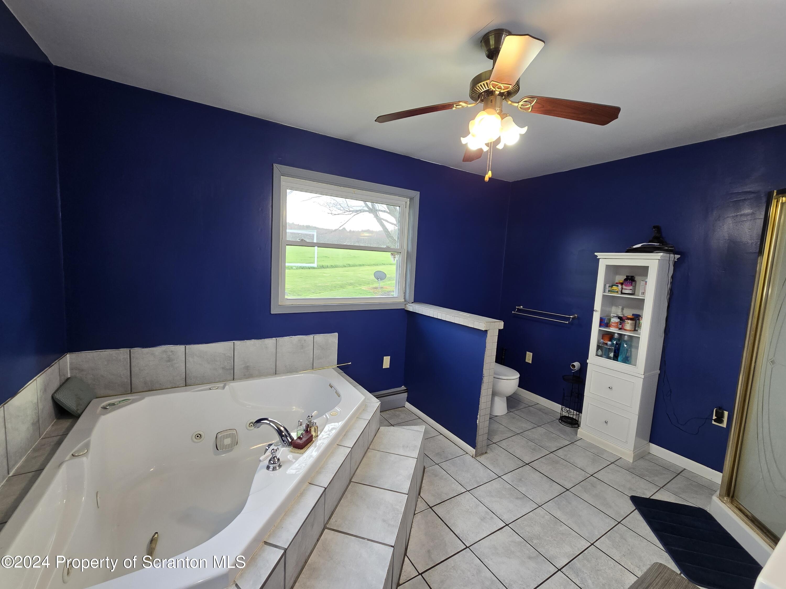 6736 Kingsley Road Kingsley, PA 18826 - Photo 24 of 42 a bathroom with a bathtub and a chandelier